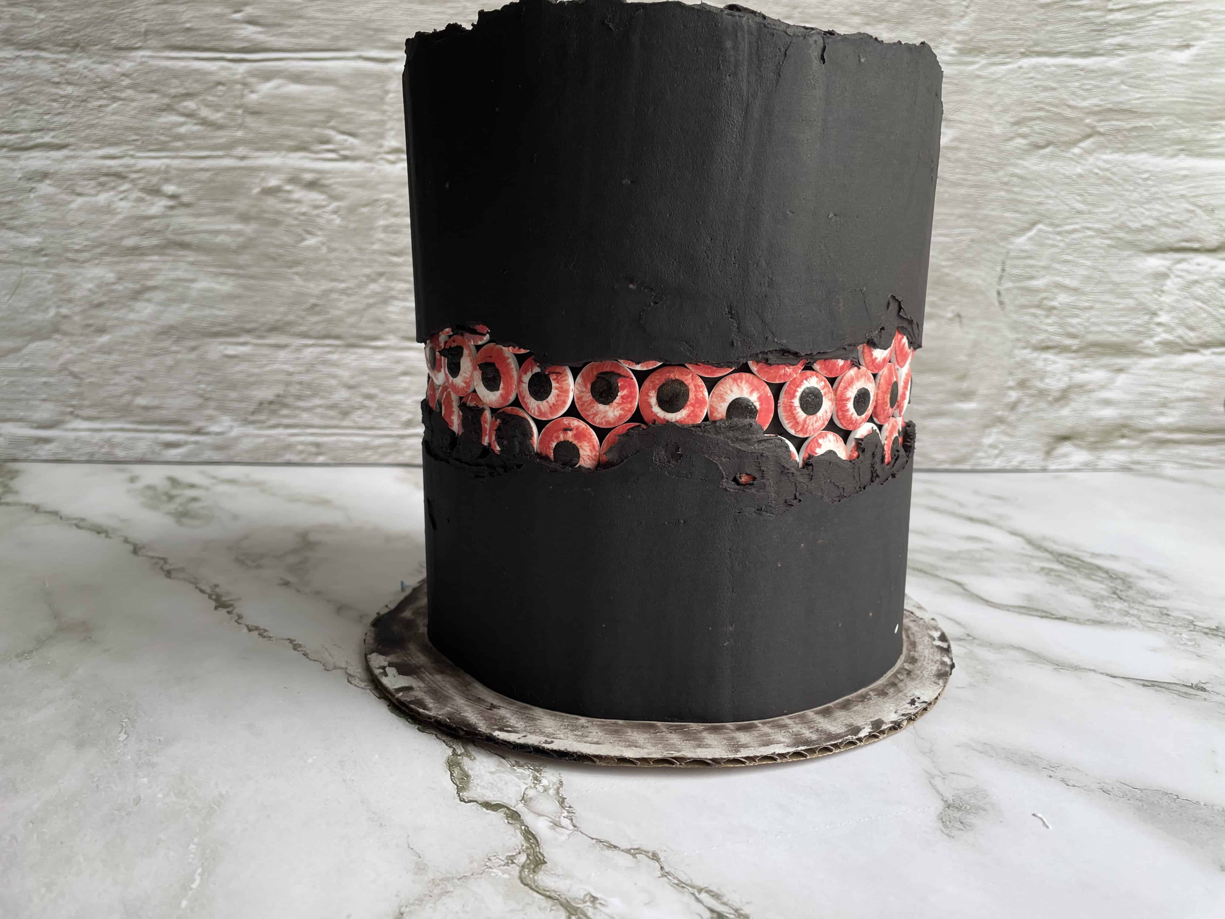 Red velvet cake with black cream cheese frosting and a bloody eyeball faultline