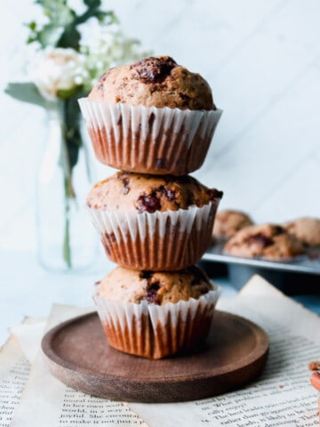 Stack of 3 muffins with more muffins in a tray in the background