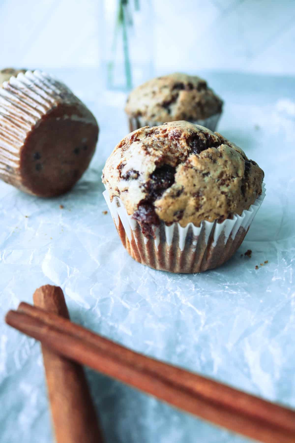 Decorative image of cinnamon chip muffins with cinnamon sticks.