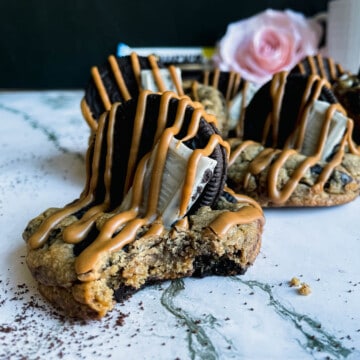 Group of 5 espresso cookies with one having a bit taken out of it.