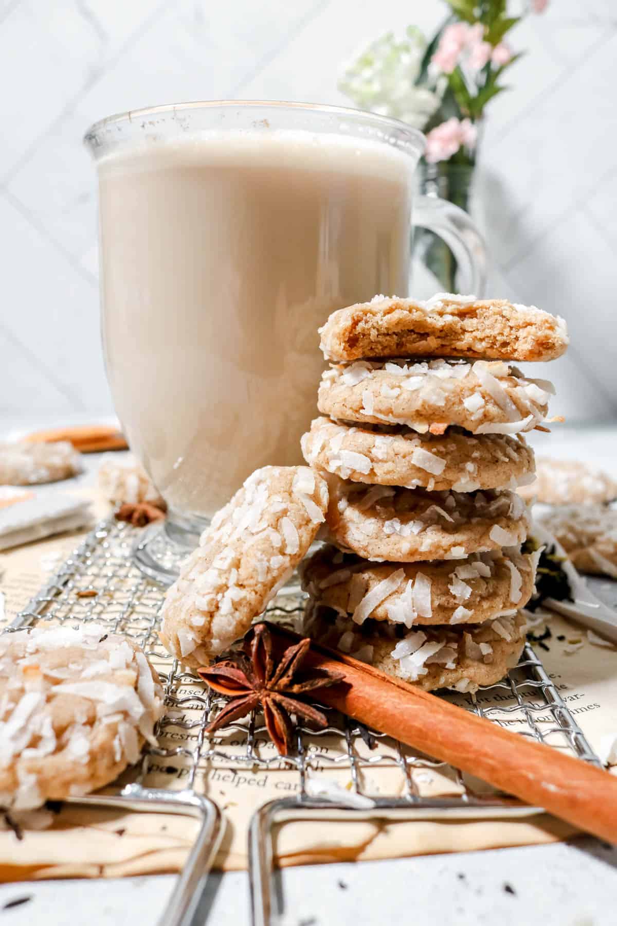 Stack of coconut chai cookies next to a coconut chai tea latte.