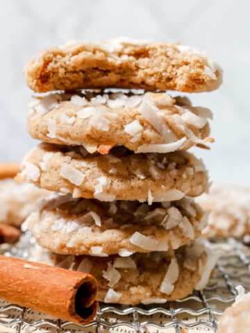 Stack of coconut chai cookies with the top one missing a bite out of it.