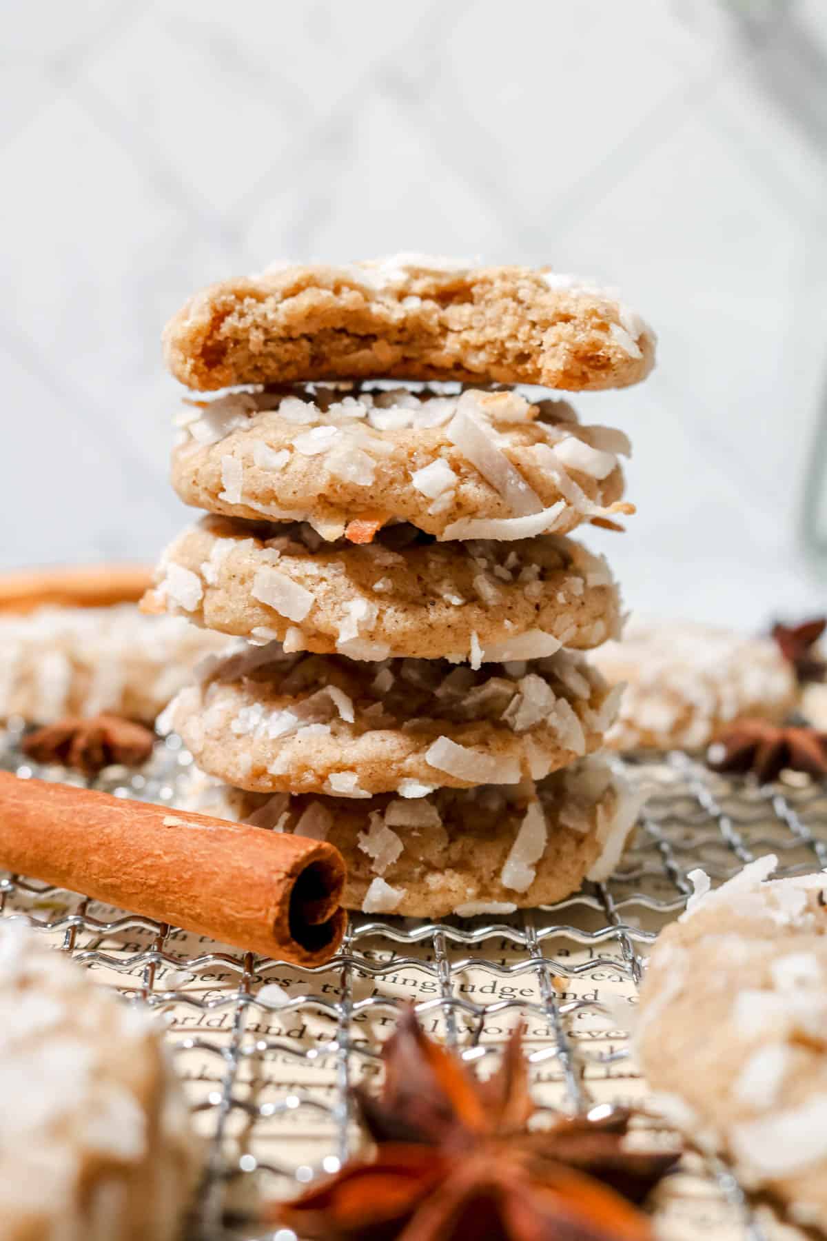 Stack of coconut chai cookies with a bite out of the top one.