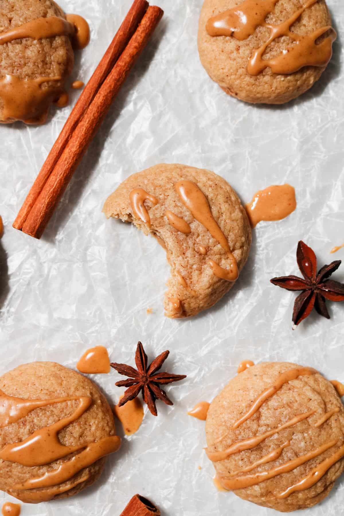 Overhead view of eggnog latte cookies on parchment paper with a bite out of one of the cookies.