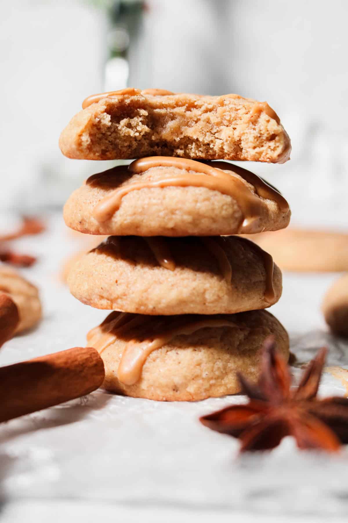 Stack of four eggnog cookies with a bit taken out of the top cookie.