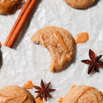 Overhead view of cookies laid out on parchment paper with a bite out of one cookie.