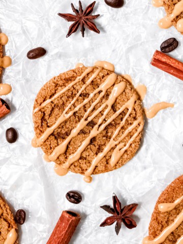 Overhead view of gingerbread latte cookies with cinnamon sticks, coffee beans, and star anise.