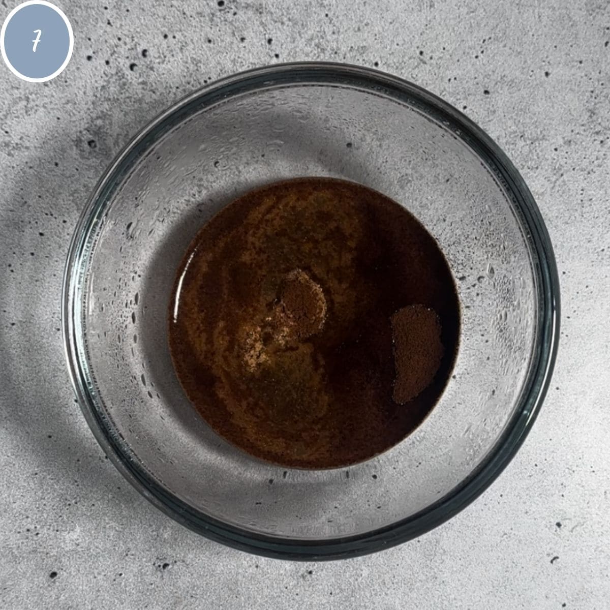 Boiling water with espresso powder and ginger in bowl.