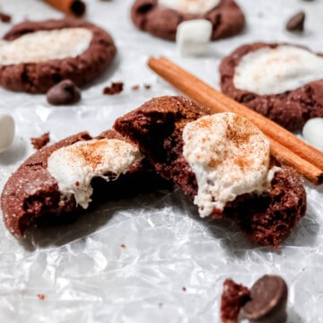 Mexican hot chocolate cookie broken in half with marshmallow oozing out.