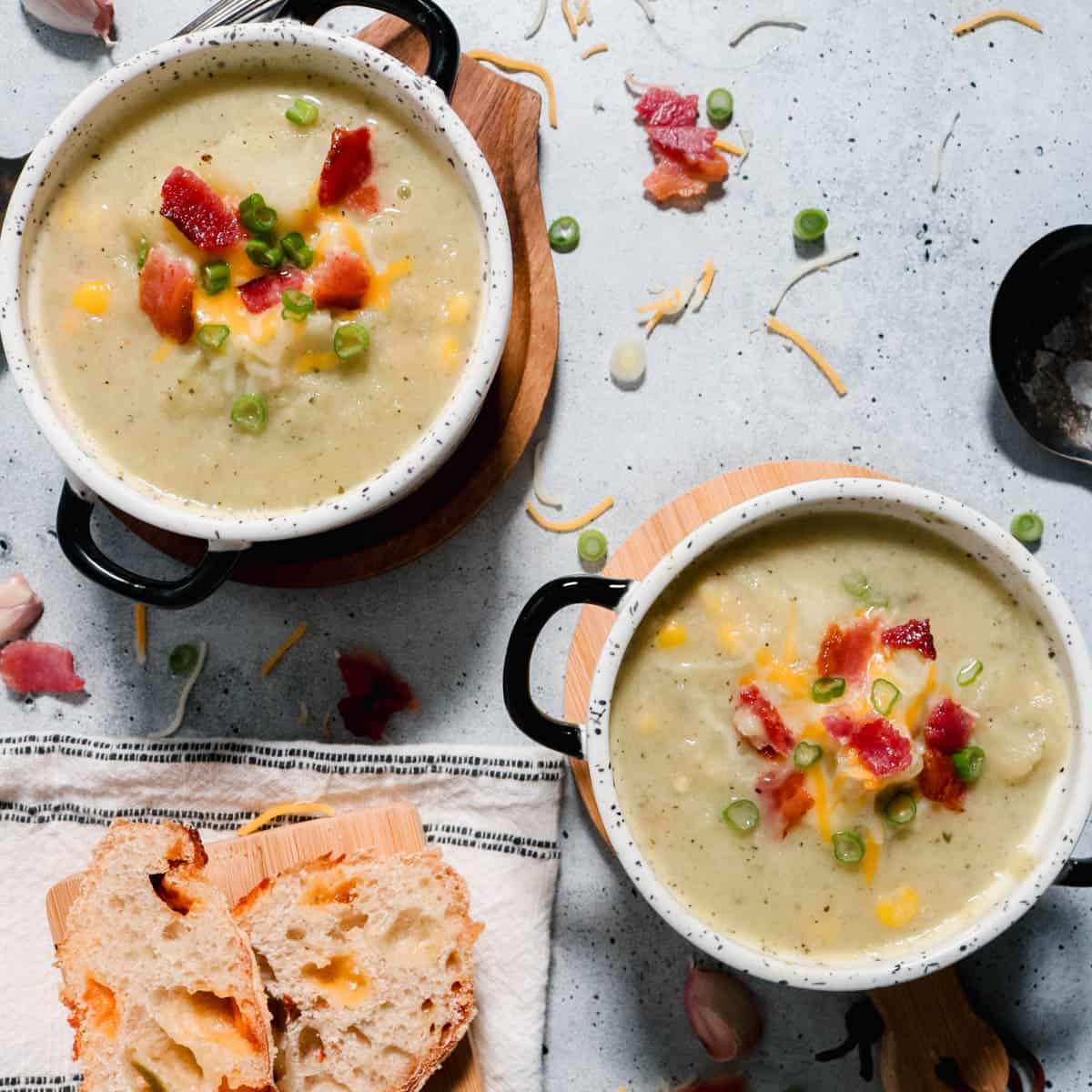 Overhead view of two bowls of cauliflower, leek and potato soup.