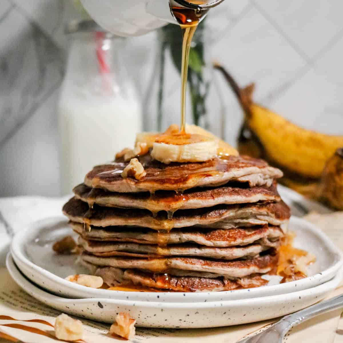 Drizzling syrup over pancakes.