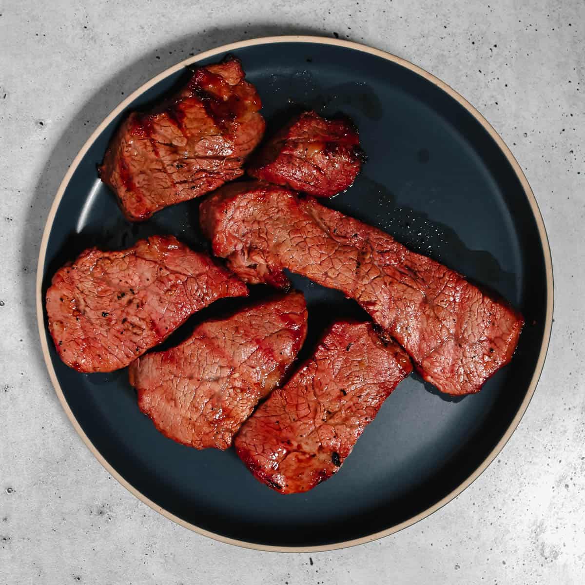 Cooked steak resting on a plate.