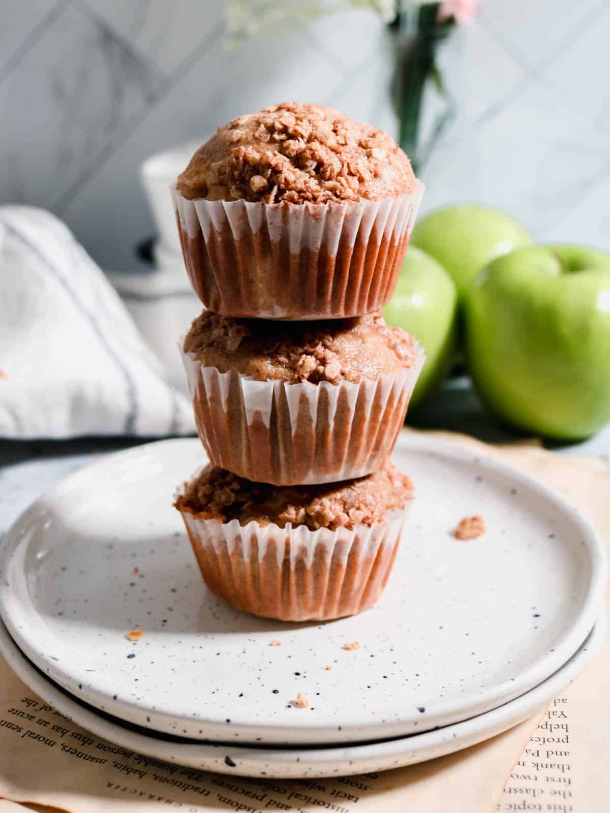 Stack of three apple sourdough muffins on a plate.