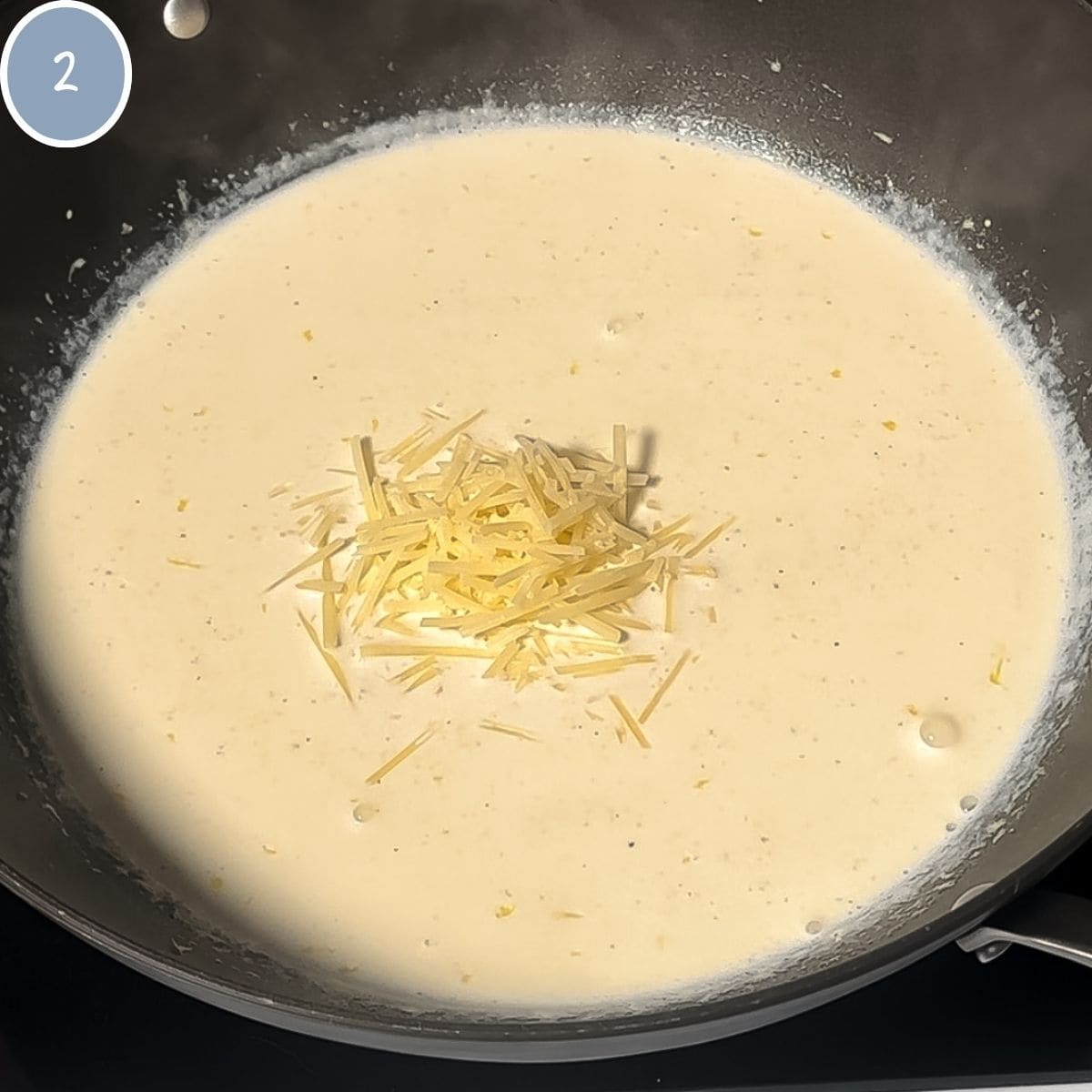 Addition of parmesan cheese to cream sauce.