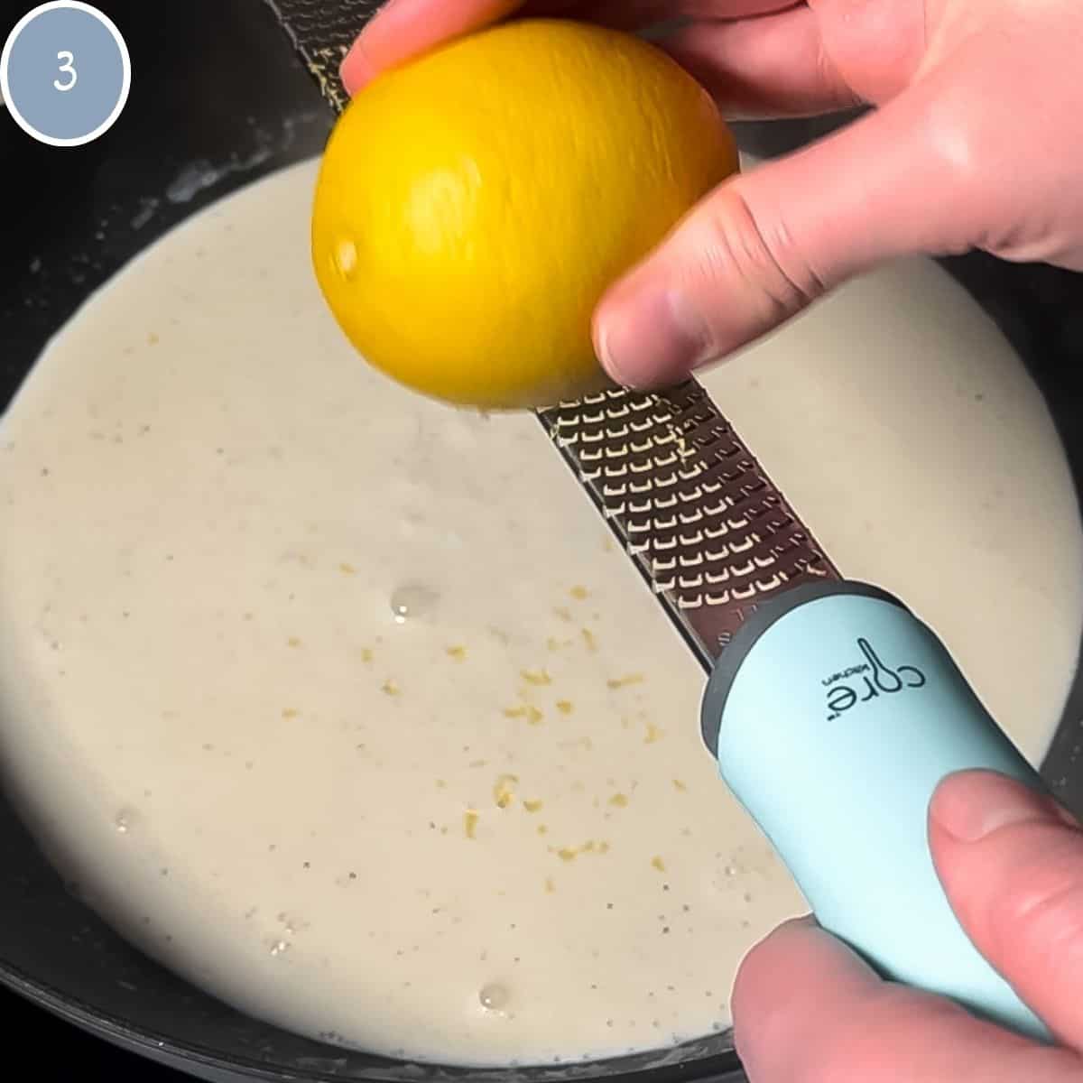 Lemon zest being added to cream sauce.
