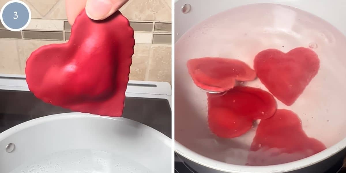 Heart shaped ravioli being cooked in a pot of boiling water.