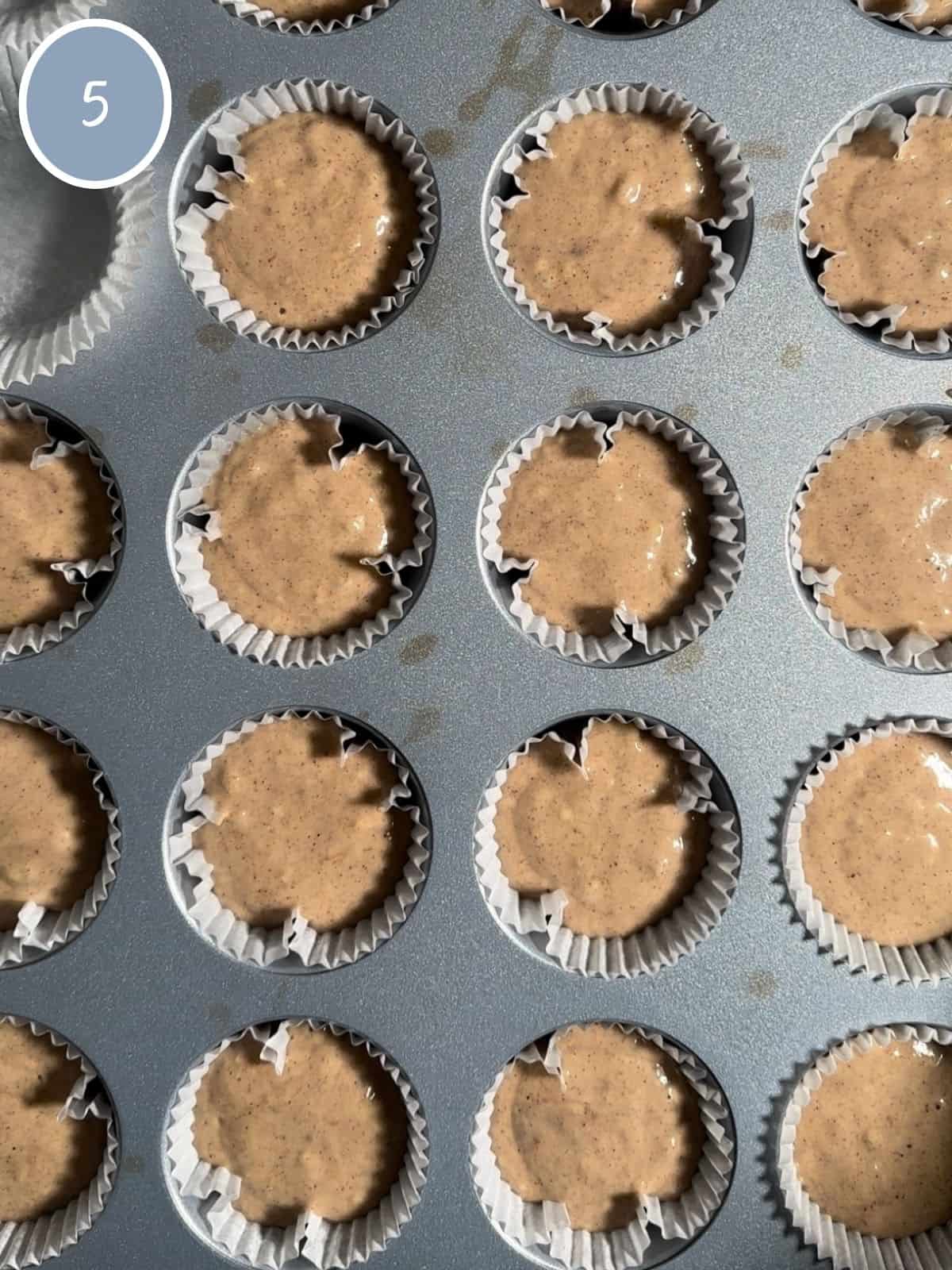 Muffin batter in the muffin tin cups.