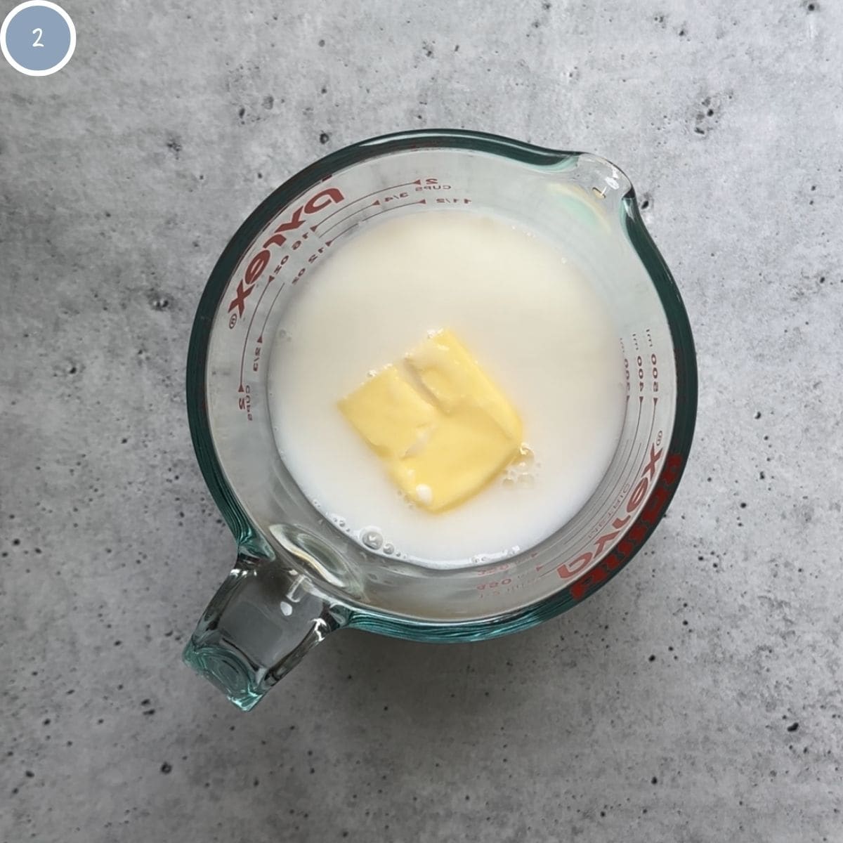 Adding water, milk, and butter to a microwave safe dish to heat it to 110F.