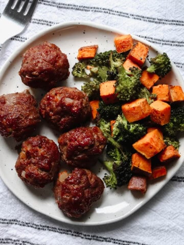 Overhead view of BBQ bison meatballs with sweet potato and broccoli on a plate.