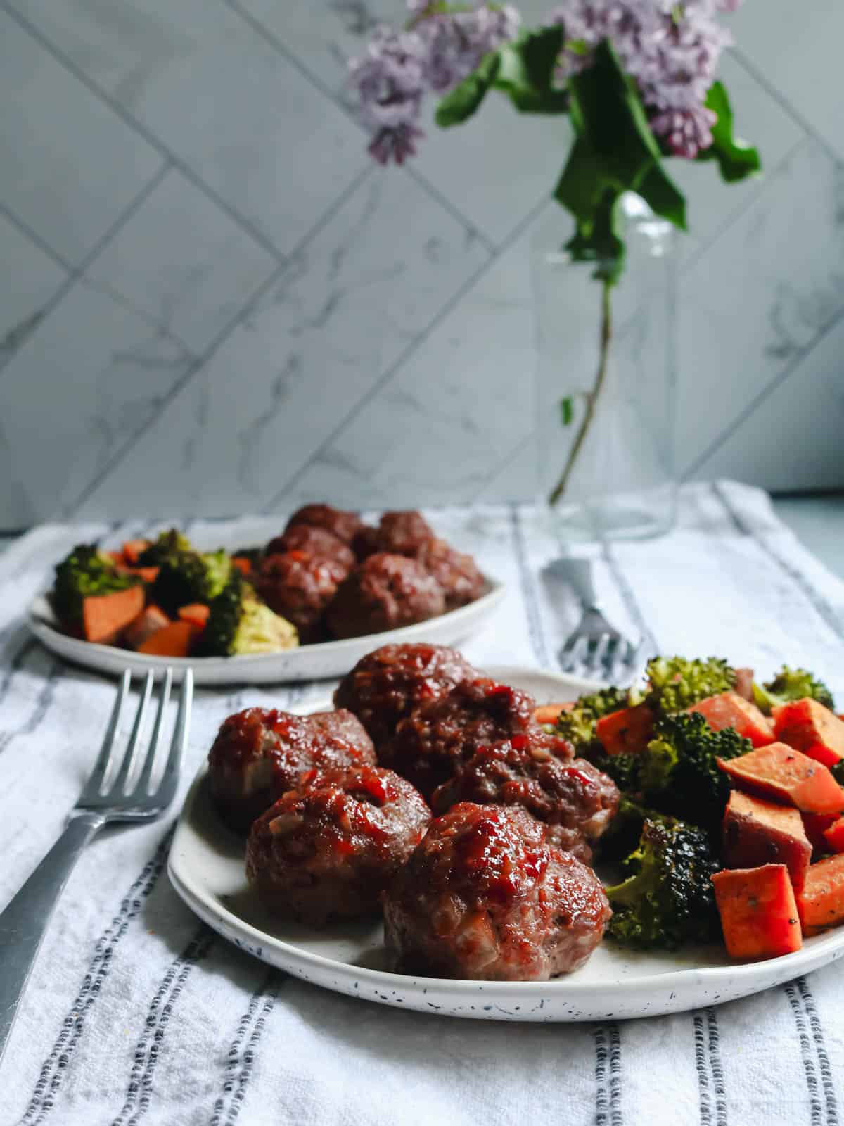 BBQ bison meatballs on a plate with sweet potatoes and broccoli.