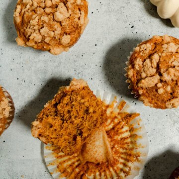 Overhead view of banana pumpkin muffins with one of them cut in half.