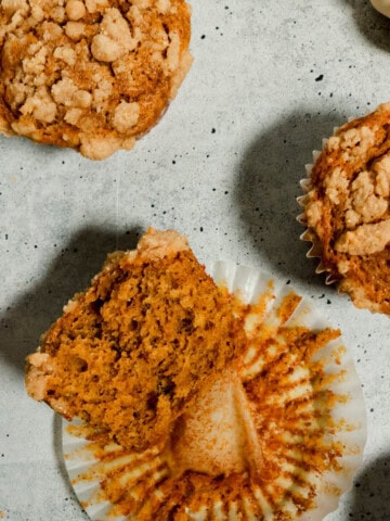 Overhead view of banana pumpkin muffins with one of them cut in half.