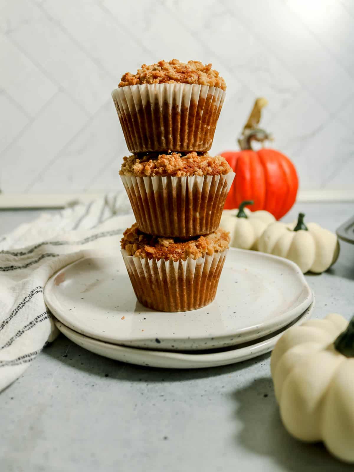 Stack of 3 muffins on a plate.