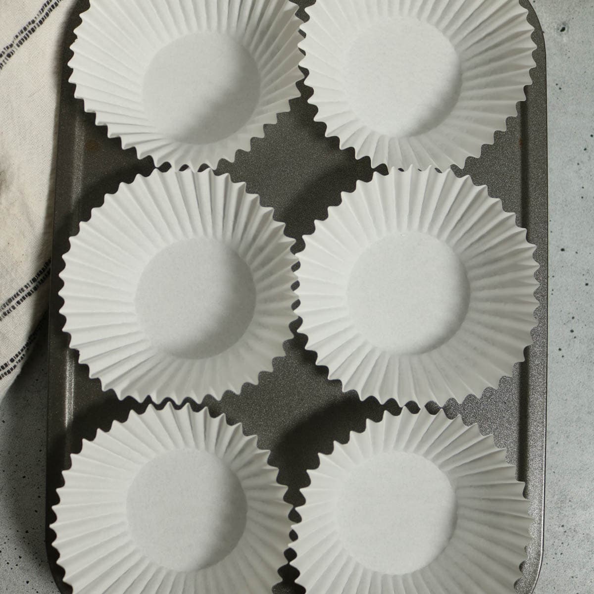 Muffin tin lined with baking cups.