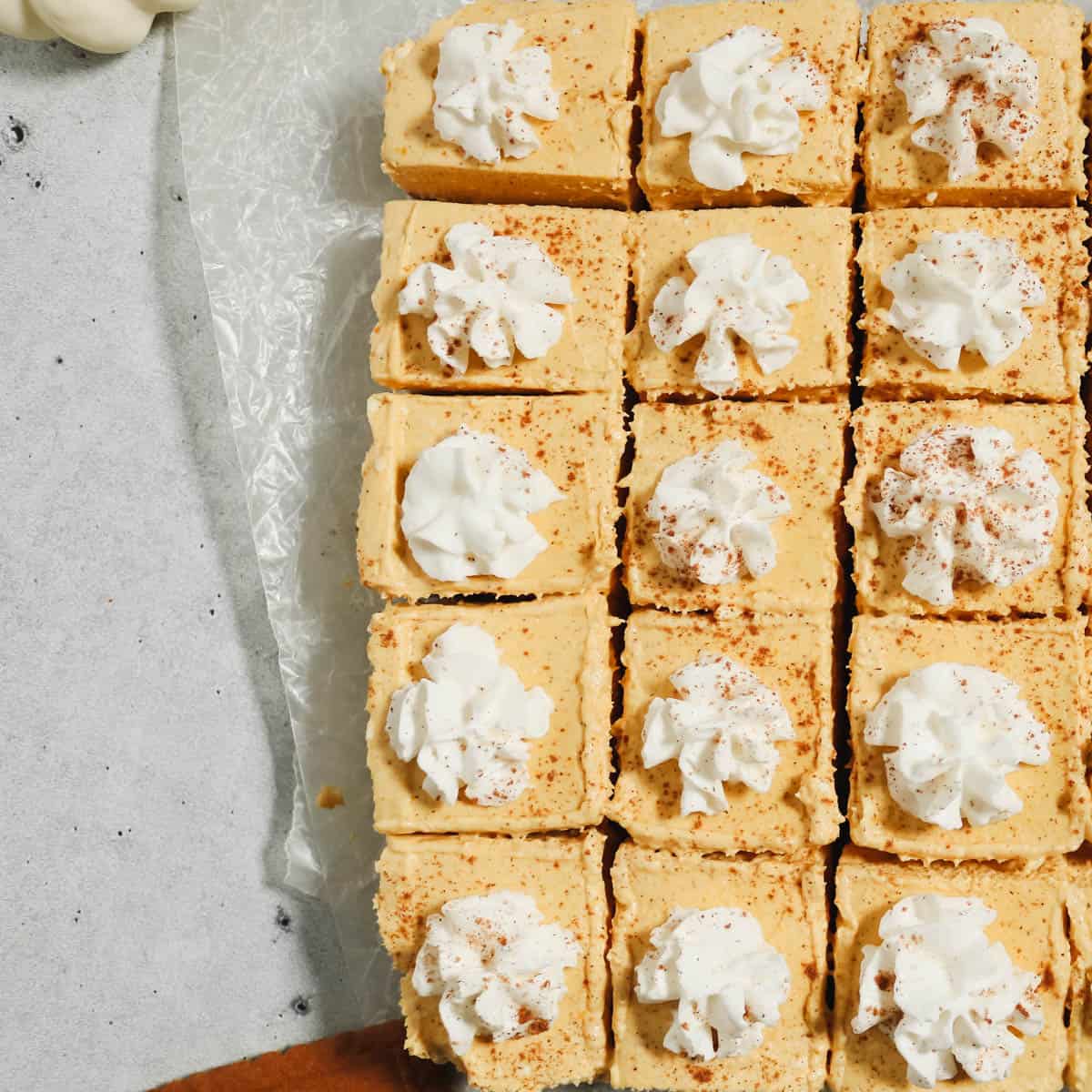 No bake pumpkin cheesecake sliced and topped with whipped cream.