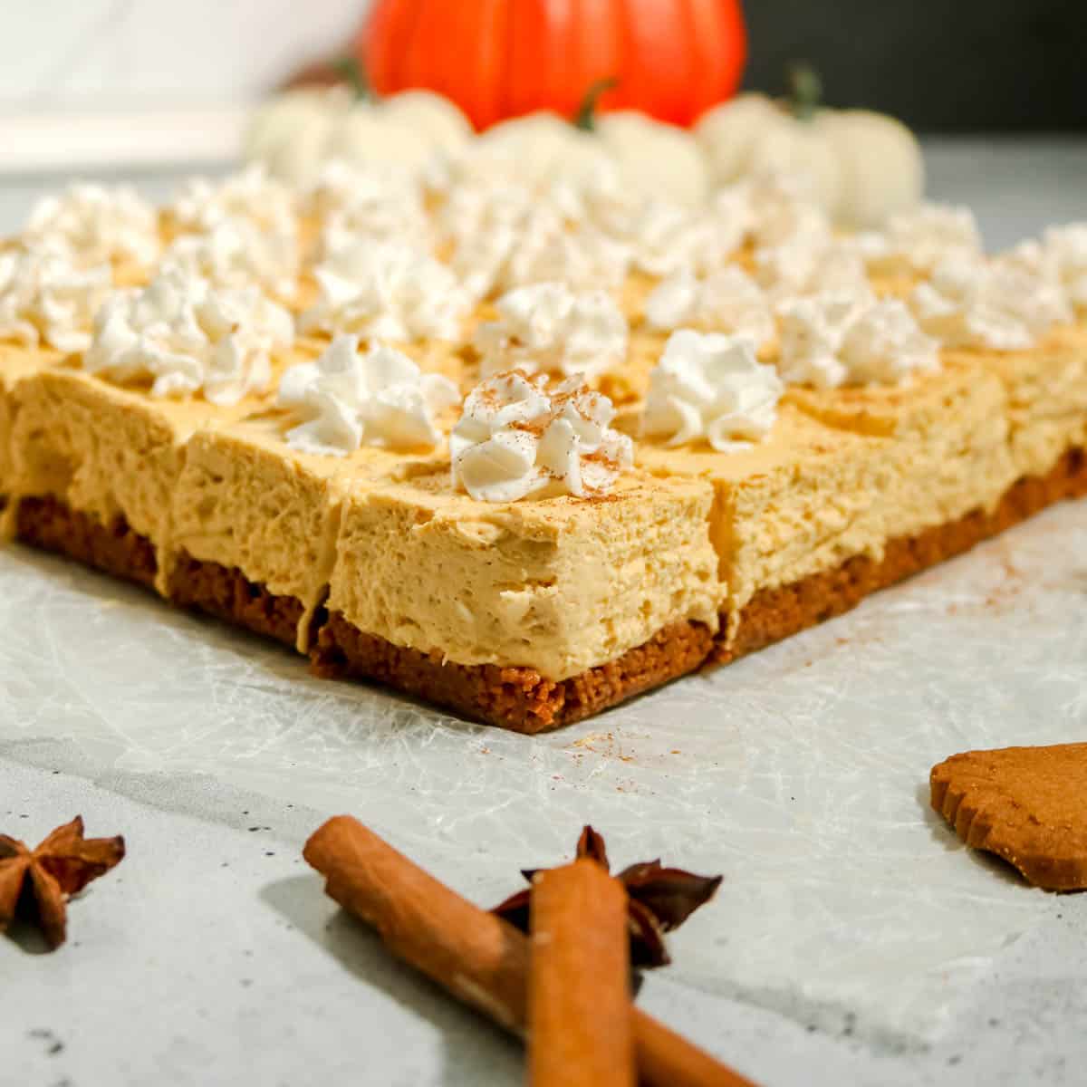 Finished no bake pumpkin cheesecake bars with whipped cream on top.