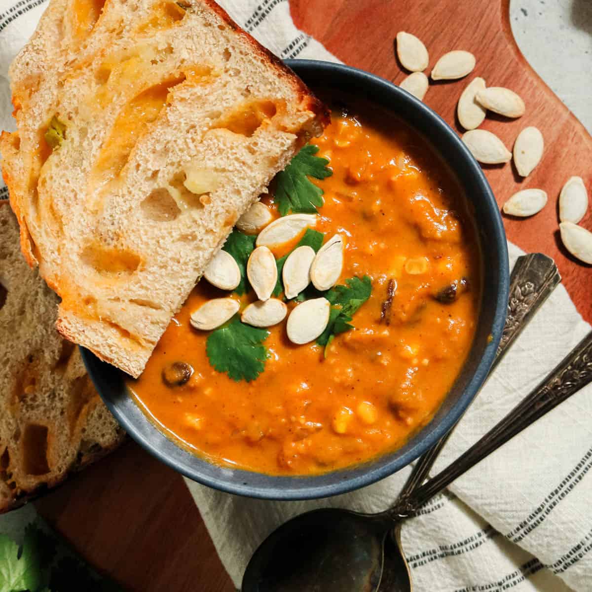 Overhead view of pumpkin chorizo soup with bread.