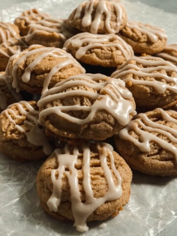 Stack of brown butter apple cider cookies on parchment paper.