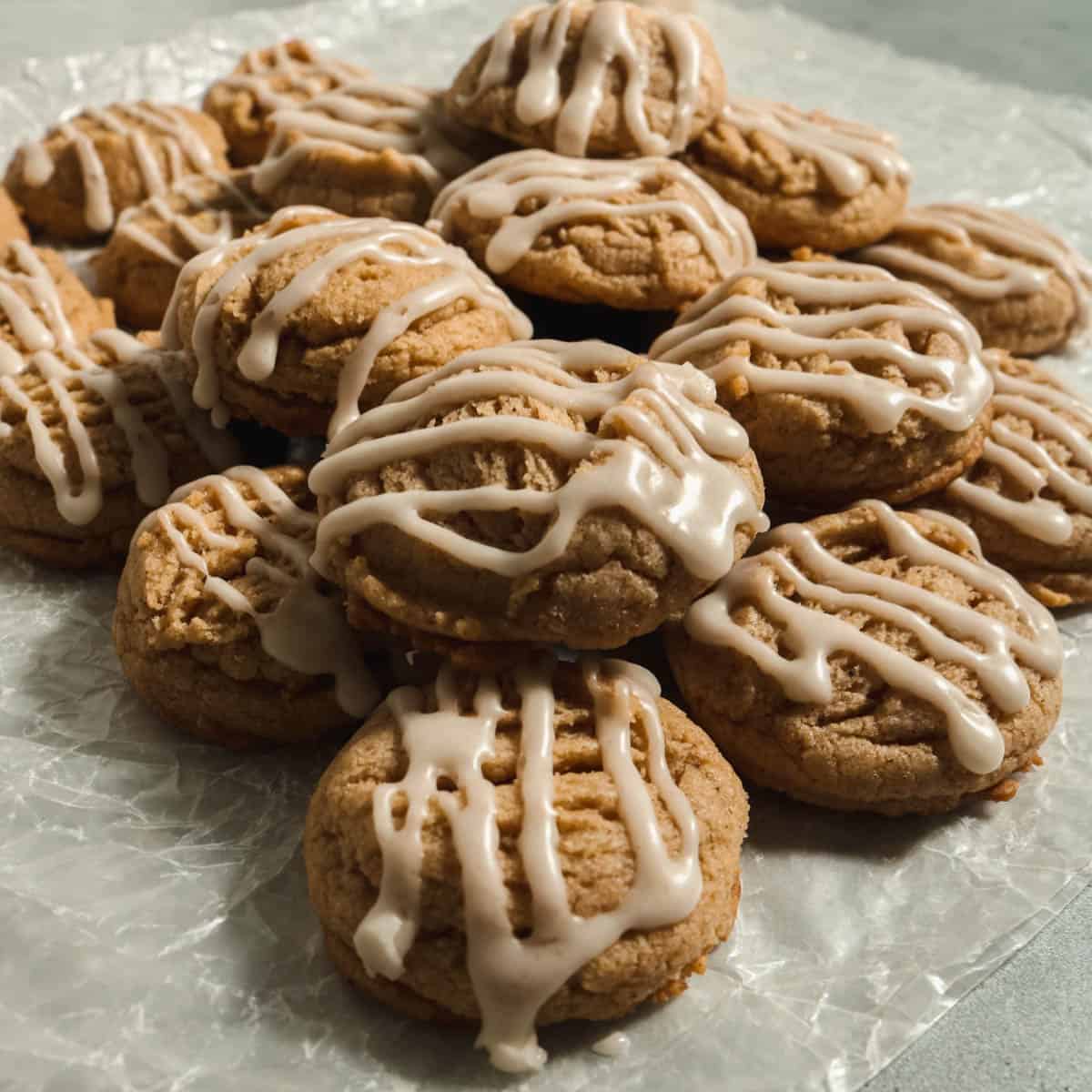 Stack of brown butter apple cider cookies on parchment paper.