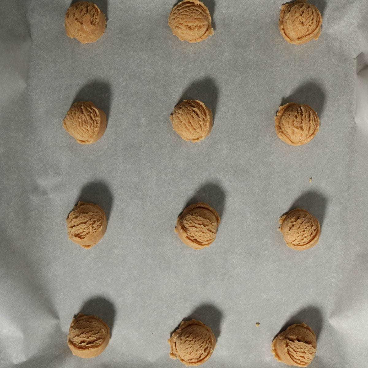 Brown butter apple cider cookie dough in balls on a baking sheet.