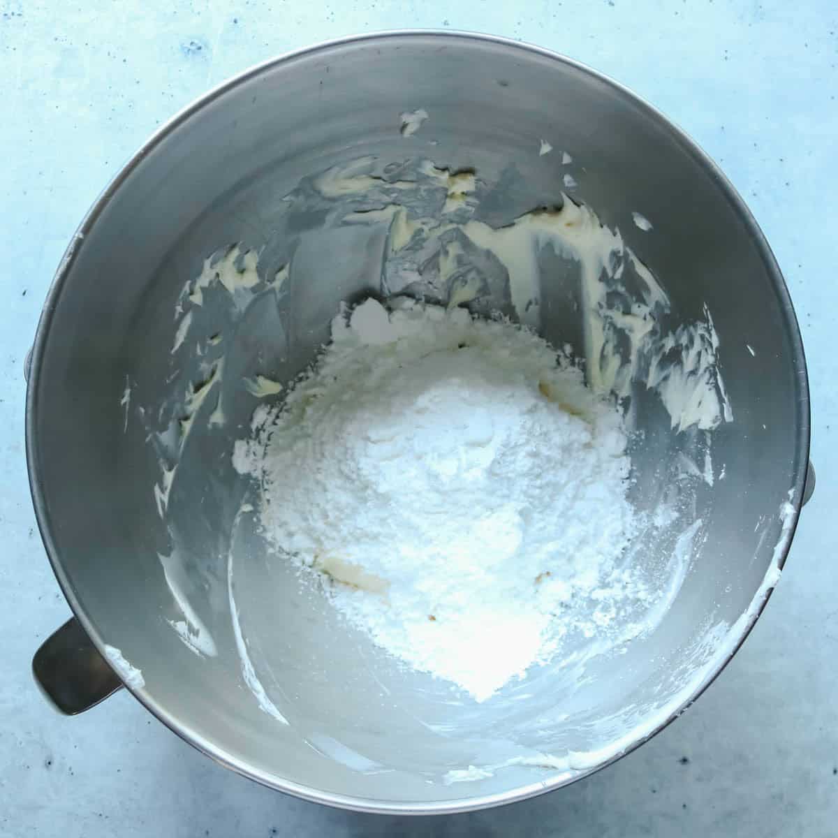 Powdered sugar and extract added to bowl with butter and cream cheese.