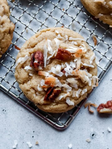 Overhead view of a coconut pecan cookie on a cooling rack.