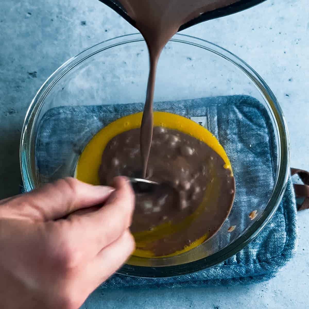 Tempering the egg yolks when making chocolate ice cream base.