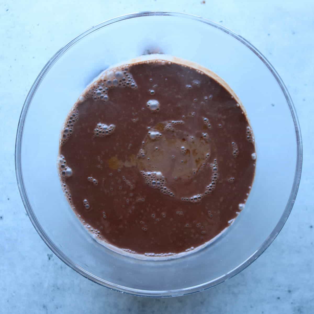 Chocolate ice cream base after being cooked and having vanilla extract added to it.