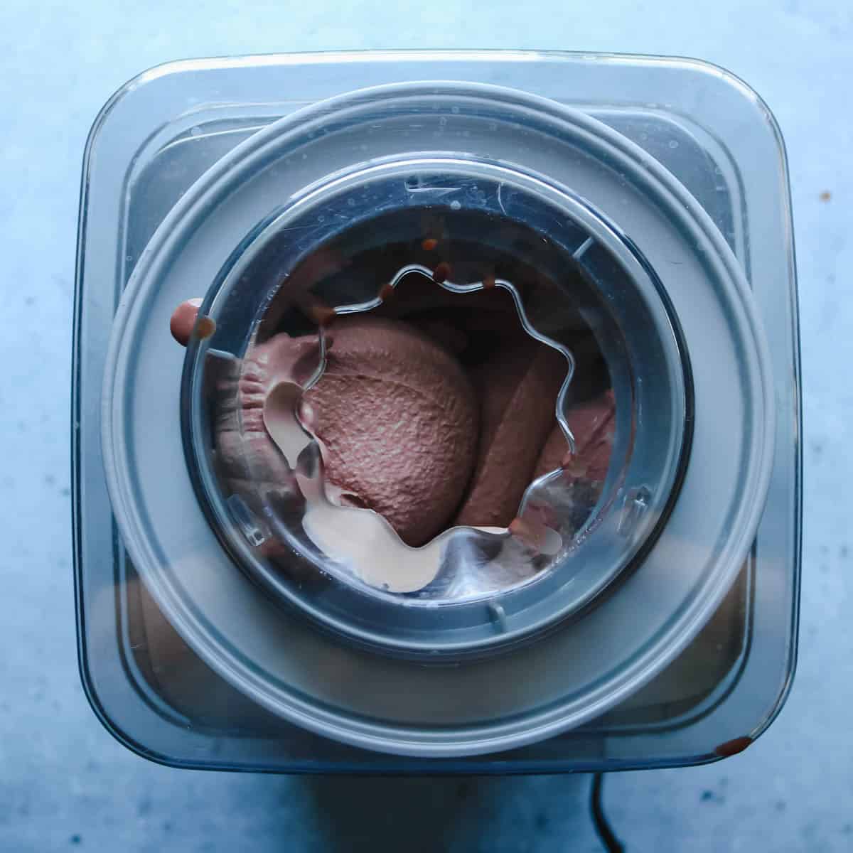 Chocolate ice cream base being churned in an ice cream maker.