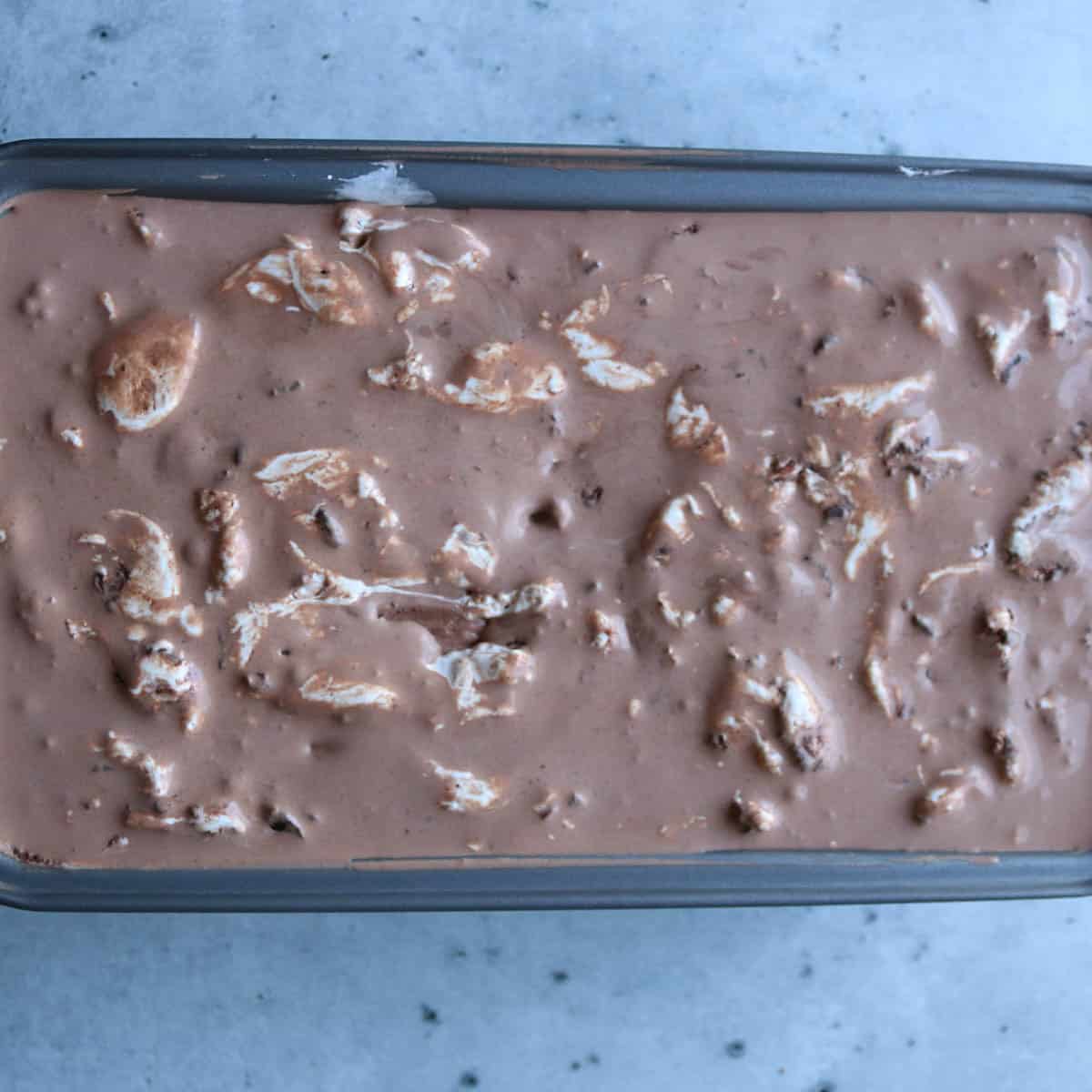 Overhead view of chocolate marshmallow ice cream in a canister.